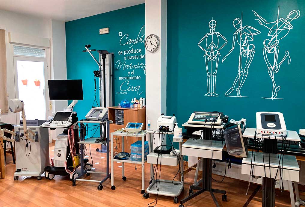 Una habitación de color azul con equipos para tratamientos de fisioterapia.