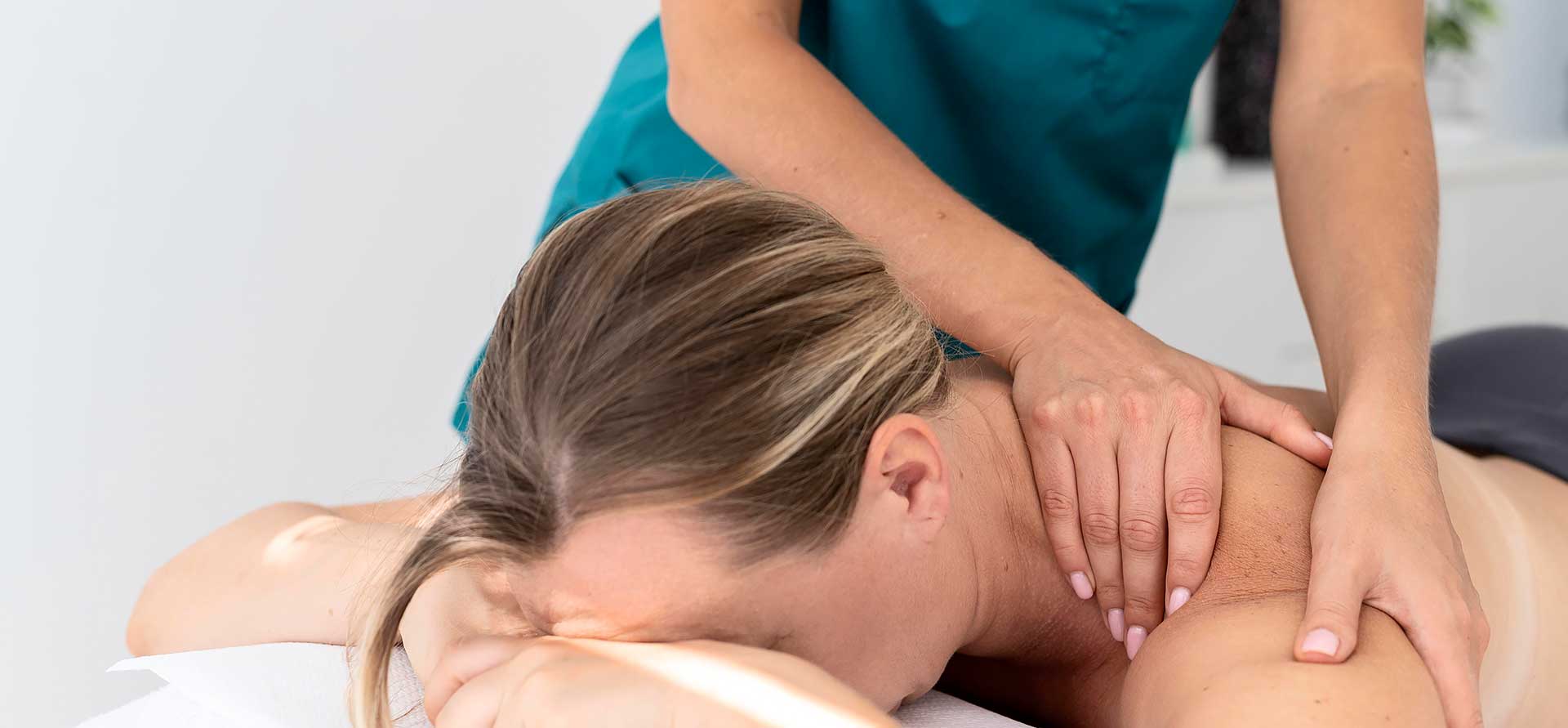 Mujer recibiendo un tratamiento de fisioterapia para aliviar la tensión muscular.